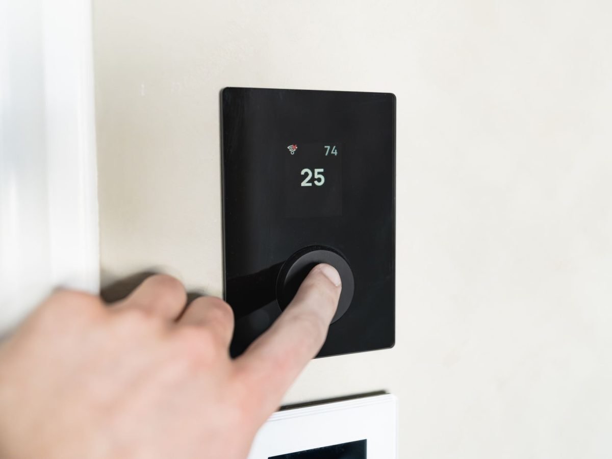 Person adjusting a smart heating control at home