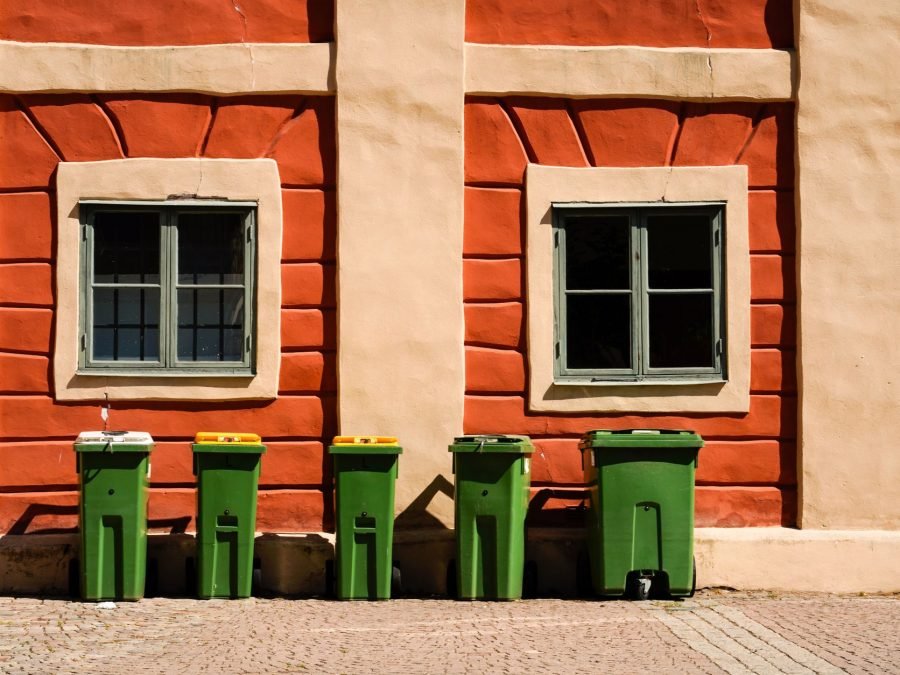 Recycling bins lined up along a building wall